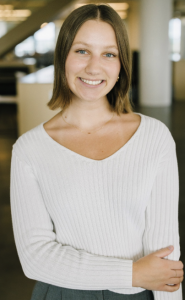 A woman wearing a white shirt, smiling. 